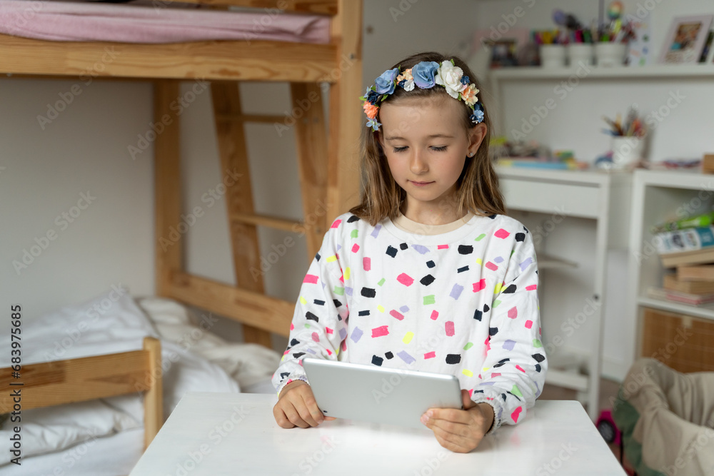 happy little girl in her play room watching play learn tablet mobile electronic book happy game