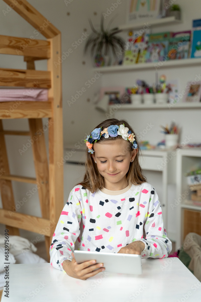 happy little girl in her play room watching play learn tablet mobile electronic book happy game