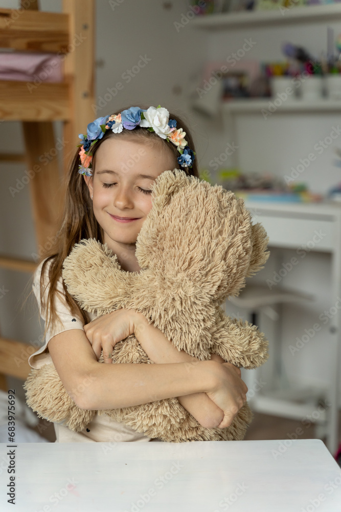 happy little girl in her play room with teddy bear hugs lonely, love,