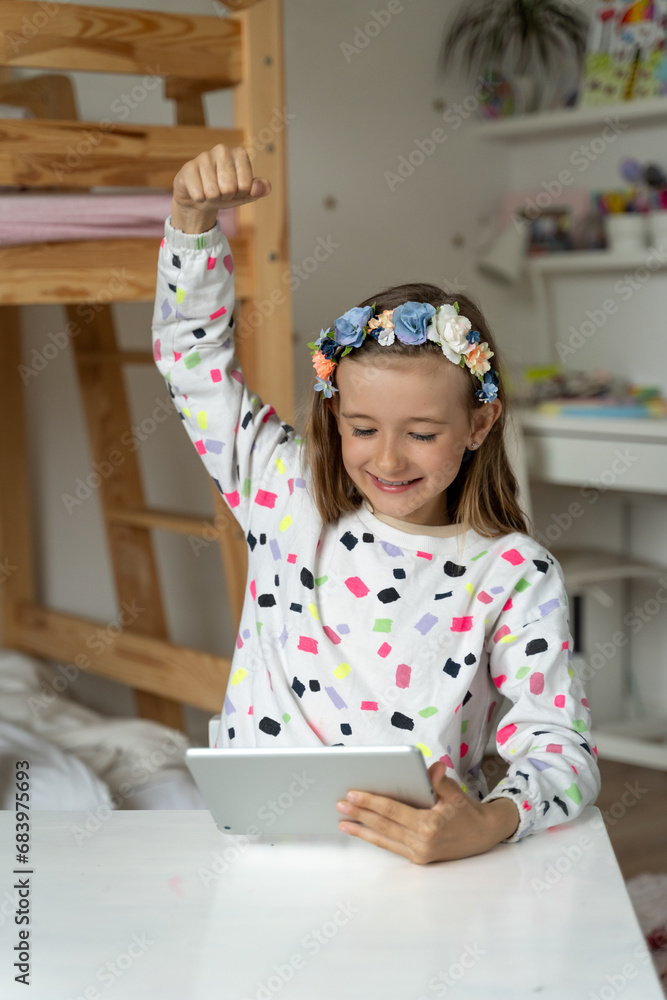 happy little girl in her play room watching play learn tablet mobile electronic book happy game