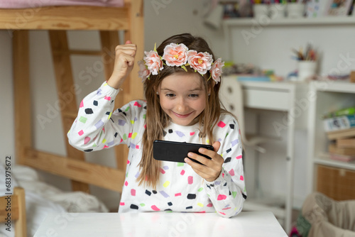 Obraz na płótnie happy little girl in her play room smart phone addicted watching video video game expressions screaming w salonie