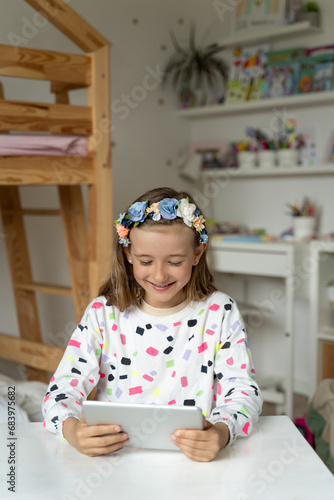 Obraz na płótnie happy little girl in her play room watching play learn tablet mobile electronic book happy game w salonie