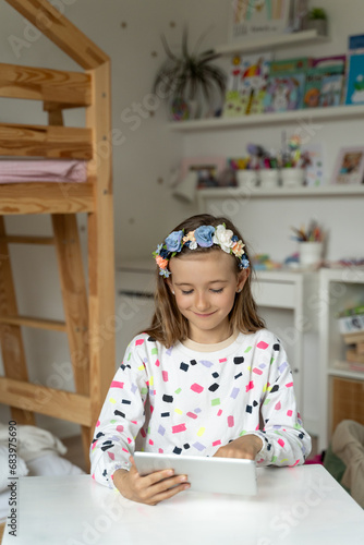 Obraz na płótnie happy little girl in her play room watching play learn tablet mobile electronic book happy game w salonie