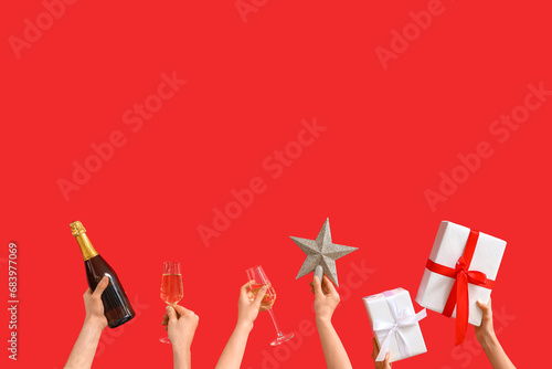 People with champagne, star and presents on red background. New Year celebration