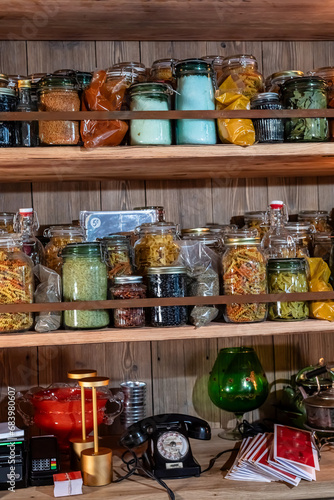 Racks with glass jars with spices and various pastes in the pantry