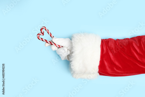 Wallpaper Mural Santa Claus hand with Christmas decorations on color background, closeup Torontodigital.ca