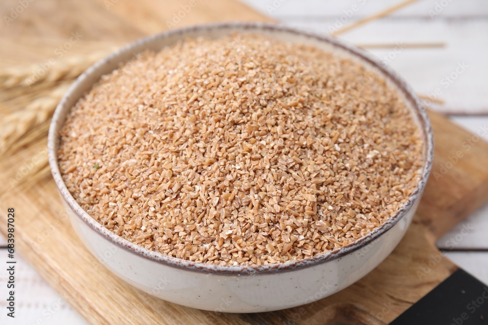 Dry wheat groats in bowl on table, closeup Dry wheat groats in bowl on table, closeup