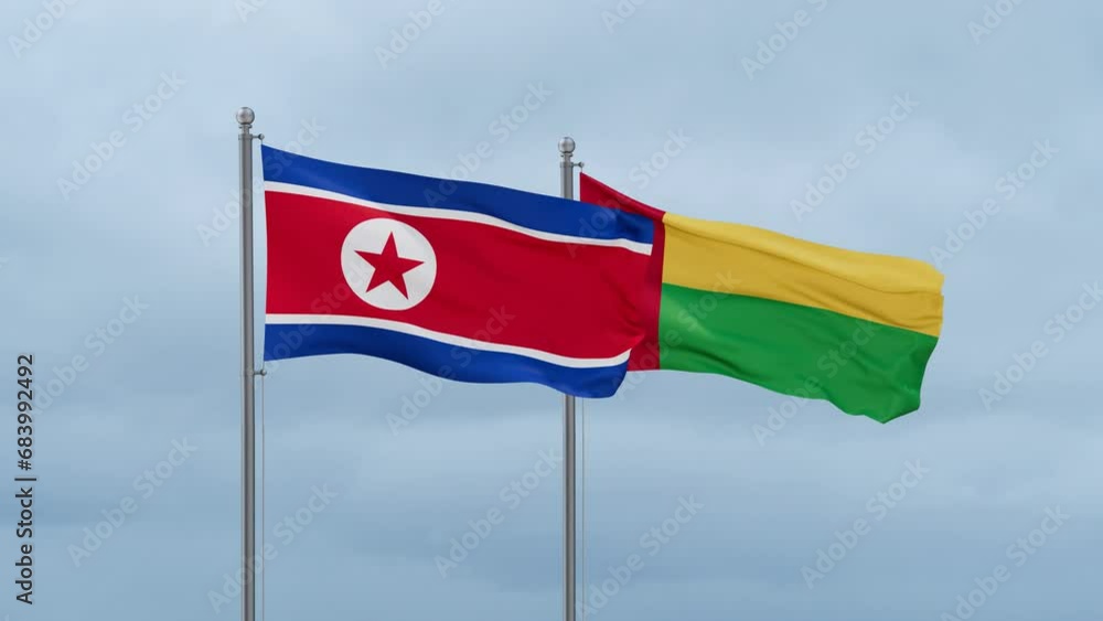 Guinea-Bissau flag and North Korea flag waving together on cloudy sky, endless seamless loop, two country relations concept Guinea-Bissau flag and North Korea flag waving together on cloudy sky, endless seamless loop, two country relations concept