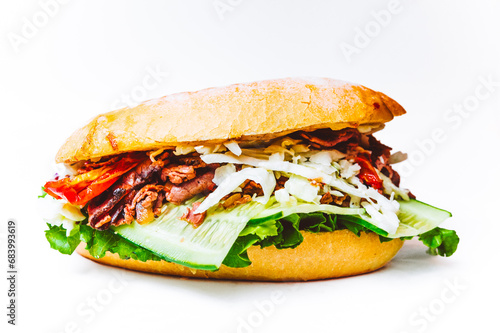 A roast beef sandwich on a hoagie roll on white paper photo