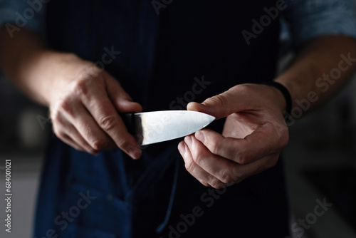 Chief Checks Sharpening Kitchen Knife In Close Up On Black Background