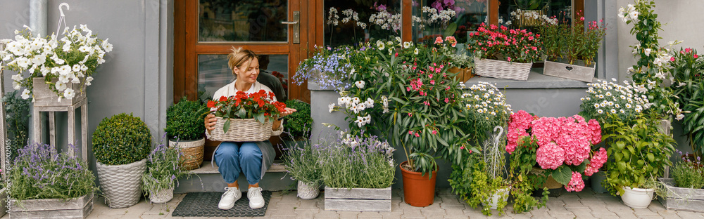 Woman florist small business owner sitting in floral store and waiting for client with houseplants Woman florist small business owner sitting in floral store and waiting for client with houseplants