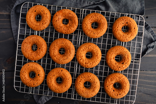 Baked Apple Cider Donuts Cooling on a Wire Rack: Freshly baked doughnuts cooling on a wire fack viewed from directly above photo