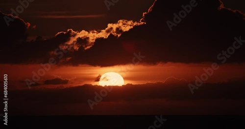 4K sunrise dawn daybreak sunup timelapse above sea horizon. golden rays breaking through dramatic clouds in majestic early morning sky