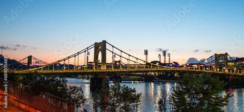A Majestic Bridge Connecting the Cityscape to Nature's Serene Waterfront at dusk in Pittsburgh photo