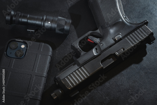 Self-defense equipment, 9mm pistol, cell phone and flashlight.