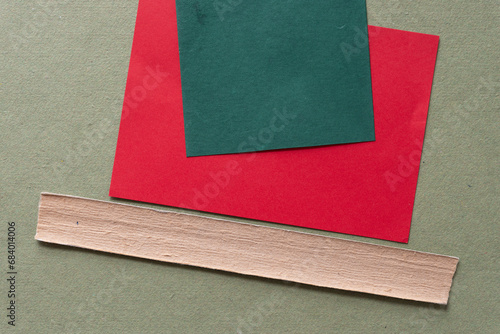 background composed of red card green tile and bookbinding spine stiffener or stripe on rough green paper photo