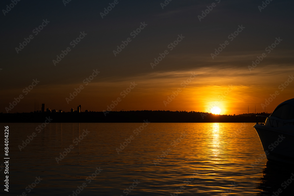 Sunset over Lake Washington, silhouette of boat in foreground
