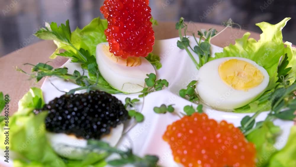 Put black caviar on an egg to serve delicious healthy food Halves of a hard-boiled chicken egg with red caviar on a wooden background. Put black caviar on an egg to serve delicious healthy food Halves of a hard-boiled chicken egg with red caviar on a wooden background.