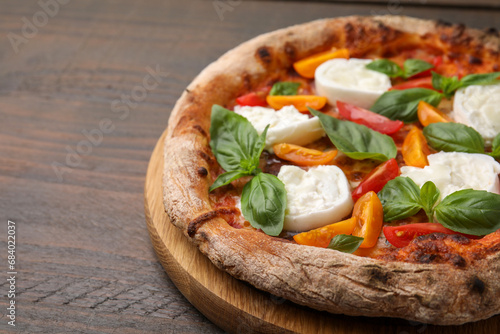 Delicious pizza with burrata cheese, tomatoes and basil on wooden table, closeup. Space for text