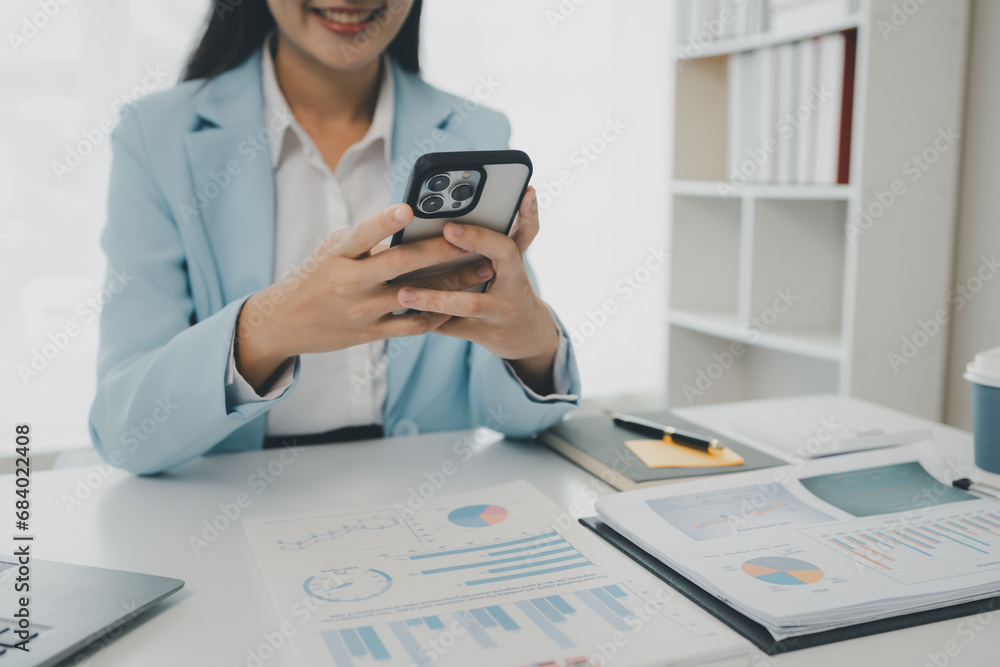 An entrepreneur is talking on the phone with a company customer, Businesswoman is sitting and working in the office, Recording various information on paper,