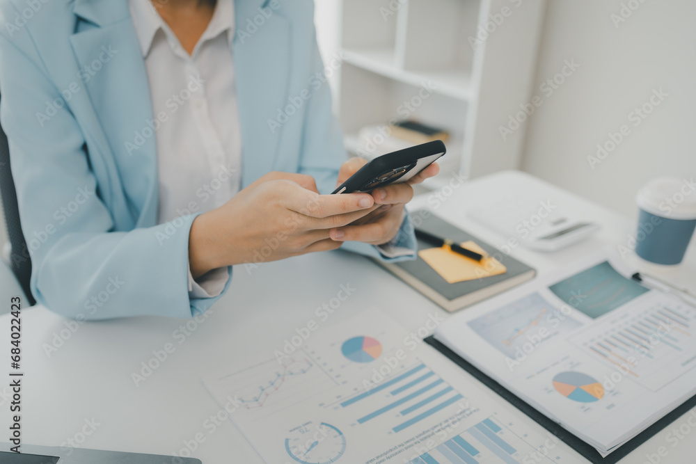 Fototapeta premium An entrepreneur is talking on the phone with a company customer, Businesswoman is sitting and working in the office, Recording various information on paper,