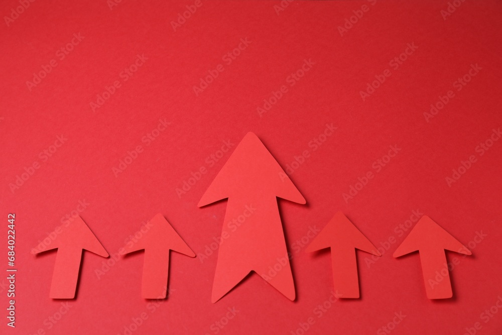 Many paper arrows on red background, above view. Space for text Many paper arrows on red background, above view. Space for text