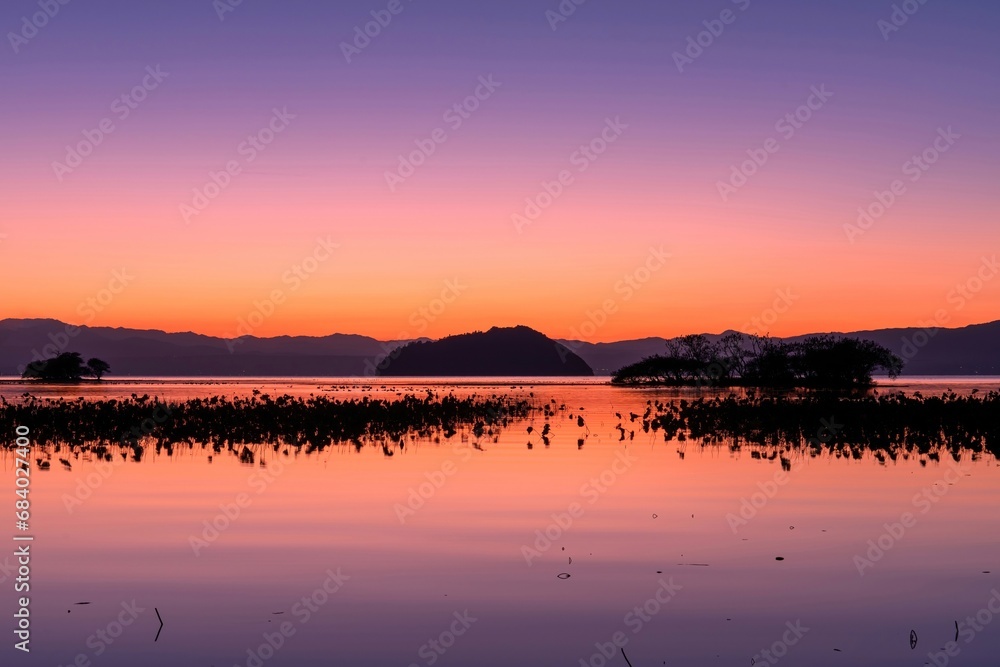 夕焼けに染まる幻想的な竹生島の情景