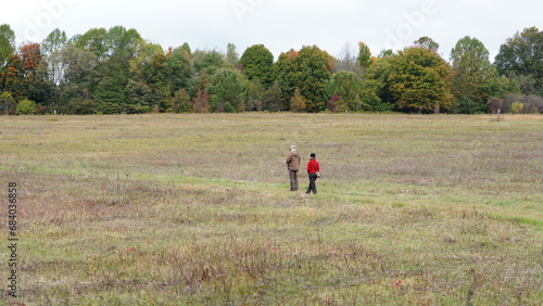 The park autumn view with the walking people on the hiking path 