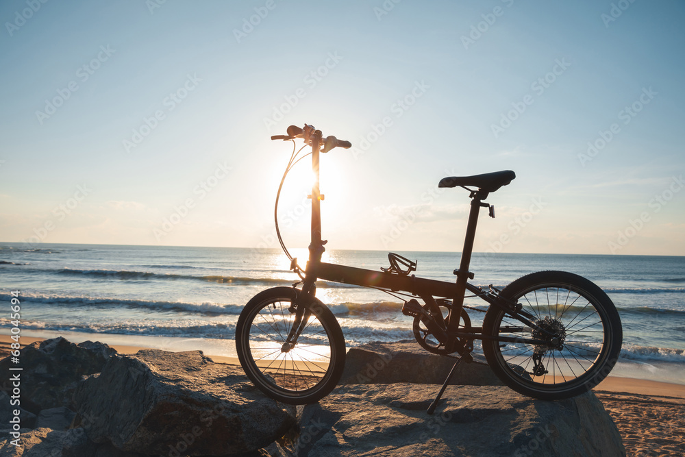 A folding bike on sunrise seaside road
