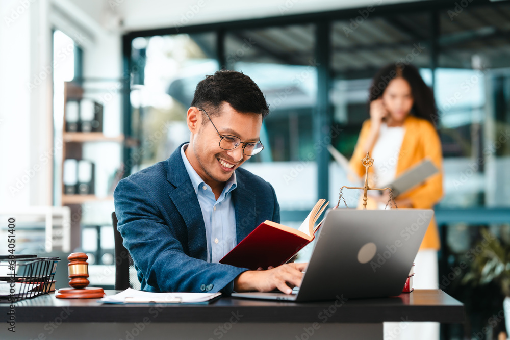 Attractive Asian businessman and an African American businesswoman, both in formal suits, intently review a contract paper together. Attractive Asian businessman and an African American businesswoman, both in formal suits, intently review a contract paper together.