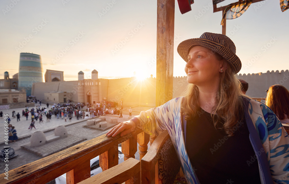 Φωτογραφία Tourist woman in ethnic dress near Madrassah in Ichan Kala of Khiva