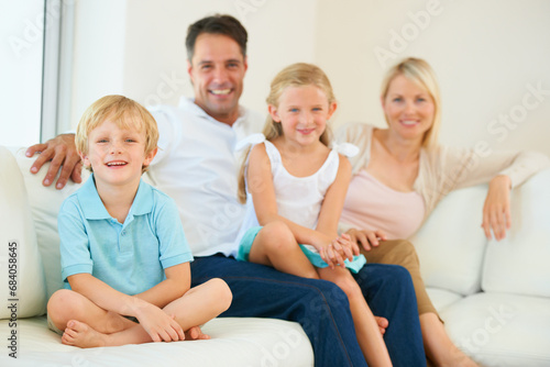 Family, portrait and happy on sofa with relax, peace and love for bonding and relationship in living room. Parents, kids and face with smile on couch of lounge with care, break and enjoyment in home
