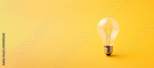 photo of a light bulb on a yellow background with copy space