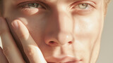 A handsome white male shielding himself from the sun, close-up. Men’s grooming. Mens cosmetics photo, beauty industry advertising photo.