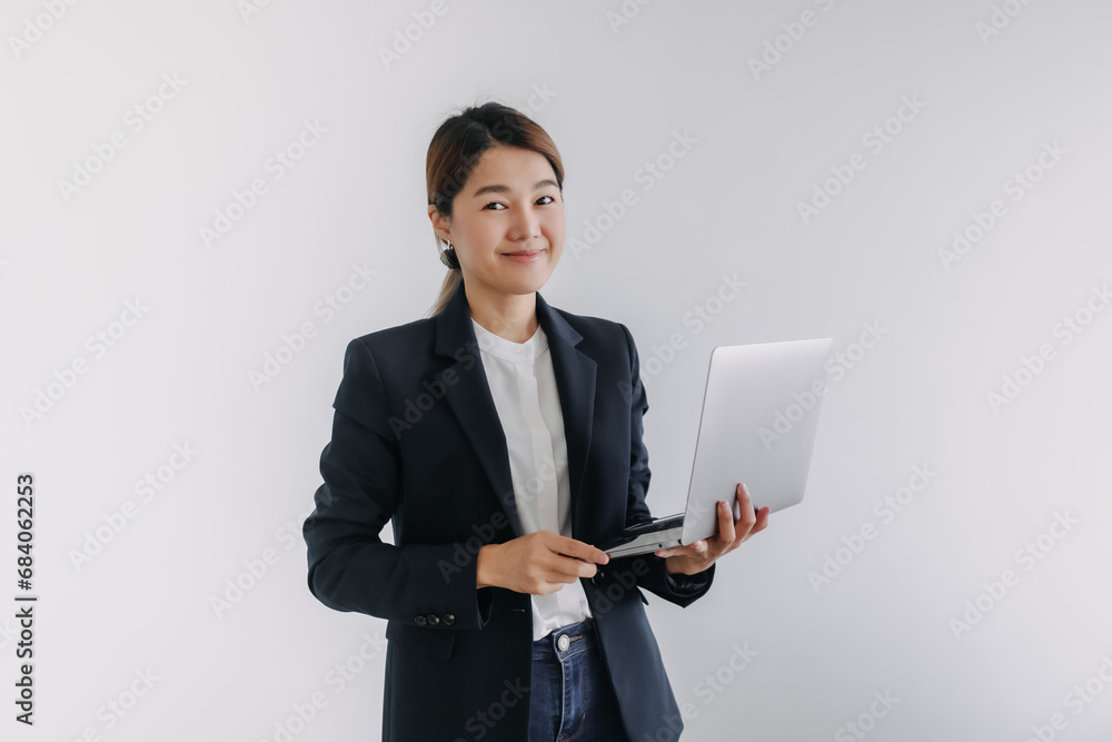 Happy asian Thai woman wear blazer holding laptop, smiling and looking at camera isolated over white background wall. Happy asian Thai woman wear blazer holding laptop, smiling and looking at camera isolated over white background wall.