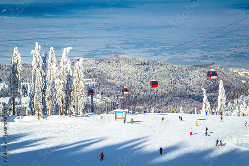 Ski gondolas and skiers on the ski slope, Romania