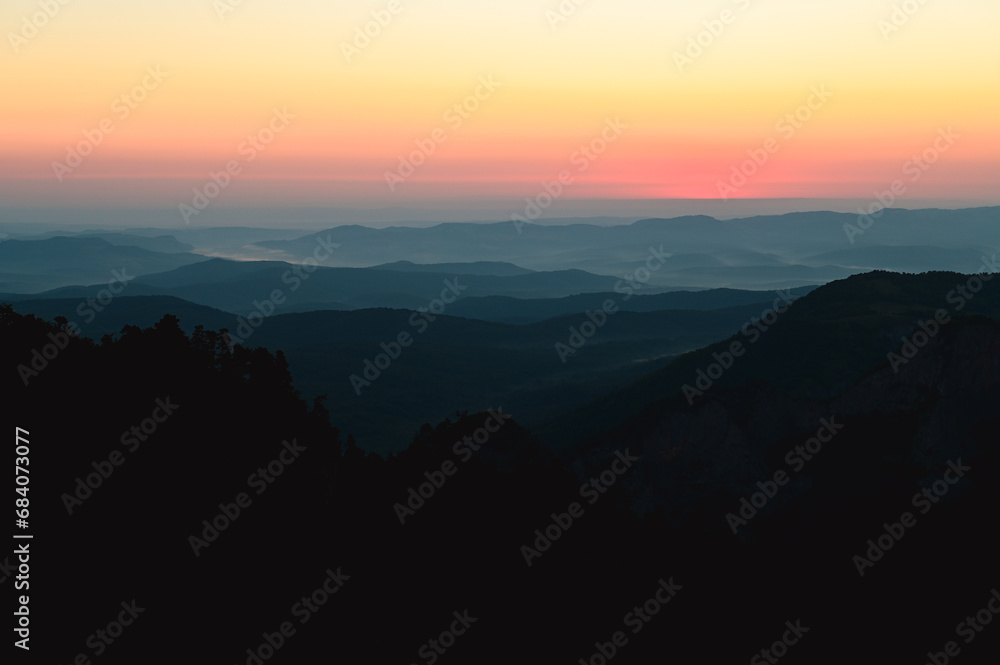 hills, forest and the sun setting behind the mountains