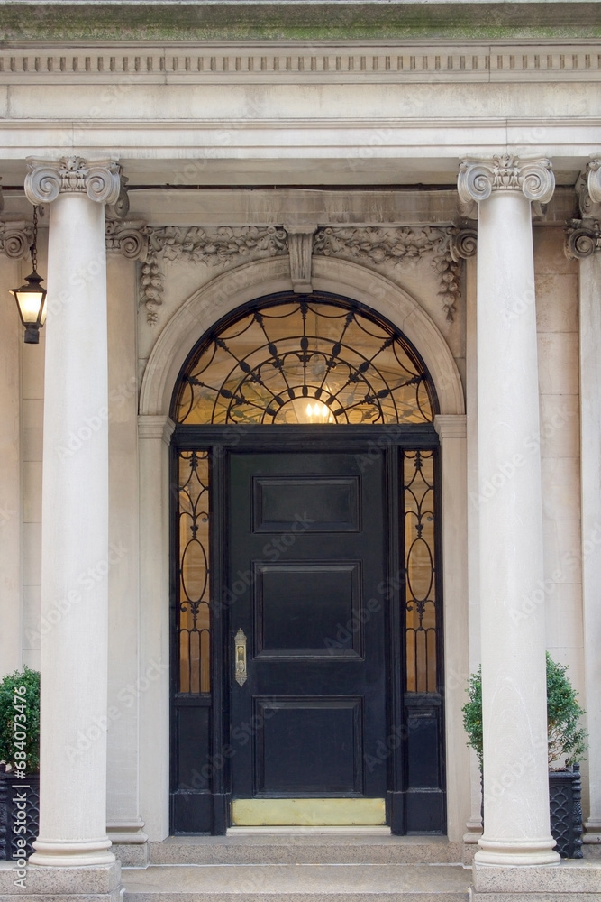 entrance to wealth and opportunity knocking at a classical front door with stone columns of an historic building entrance vertical