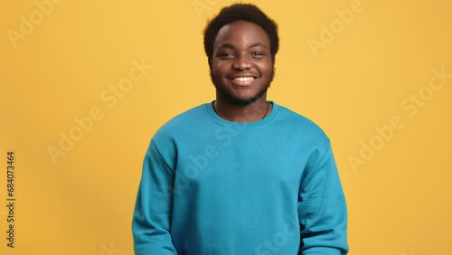 Portrait smiling Afro man shaking head yes approved agree good choice posing isolated orange studio photo