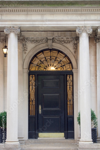 entrance to wealth and opportunity knocking at a classical front door with stone columns of an historic building entrance vertical photo