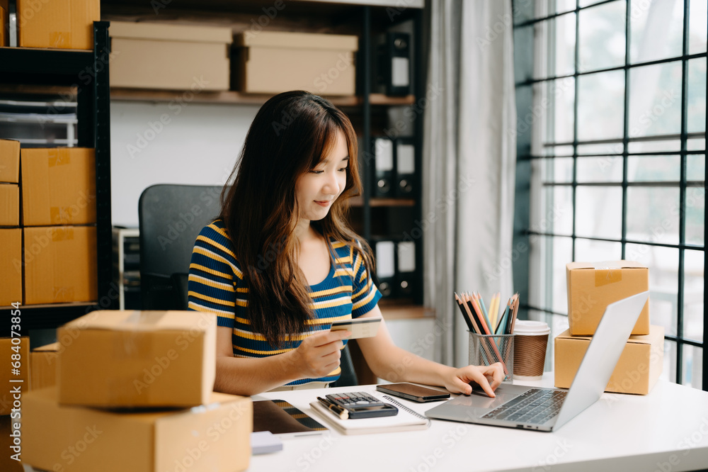 Startup small business SME, Entrepreneur owner woman using smartphone or tablet taking receive and checking online purchase shopping order Startup small business SME, Entrepreneur owner woman using smartphone or tablet taking receive and checking online purchase shopping order
