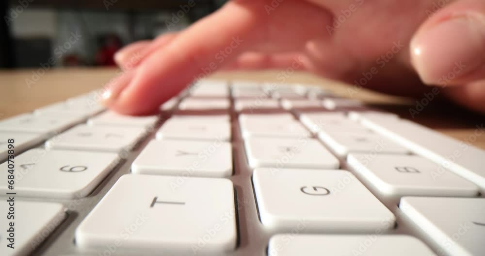 Employee types on white keyboard in office