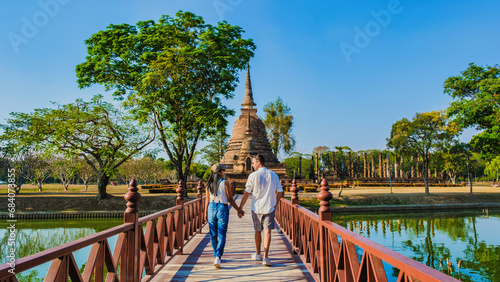 Some men and women visit Wat Sa Sit, Sukhothai Old City, Thailand. Ancient city and culture of South Asia Thailand, A couple visit Sukhothai Historical Park photo