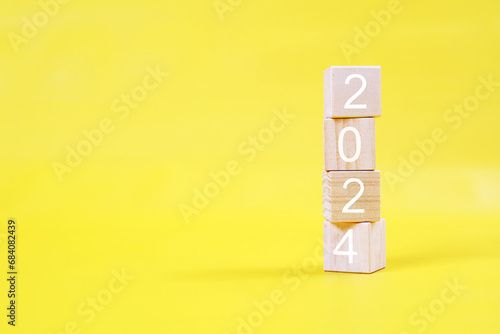 2024 new year concept. 2024 word with wooden blocks on yellow background