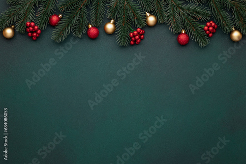 Christmas decoration on dark green background, empty space. Festive New Year mockup with tinsel. Vintage frame. Gold, red ornaments. Celebration card, bauble. Top view. Evergreen tree. Blank template.