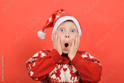 funny portrait of a boy, a child in a Santa Claus hat, Christmas