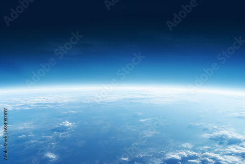 view from the space to the blue earth's surface with atmospheric haze and clouds