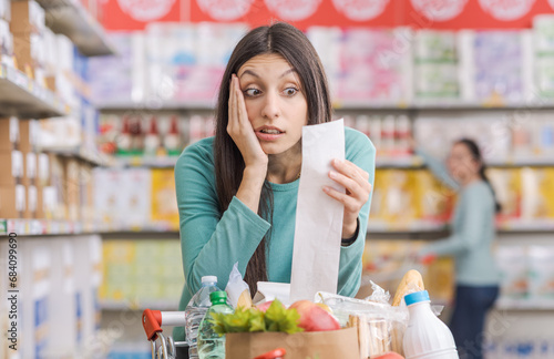Woman checking an expensive grocery receipt