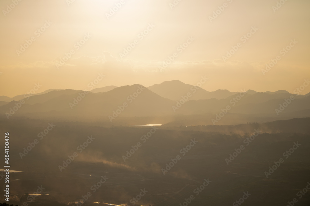 Hazy Sunrise Over Misty Mountain Layers