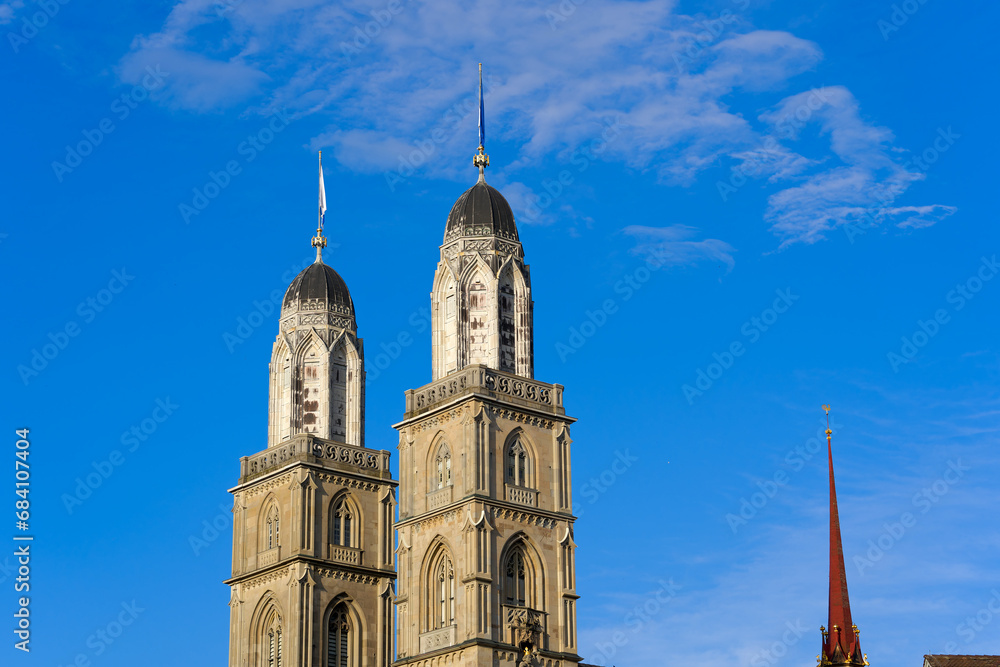 Obraz premium Twin towers with flags of City of Zürich and Canton Zürich on top of church towers of protestant church Great Minster on a sunny summer evening. Photo taken July 7th, 2023, Zurich, Switzerland.